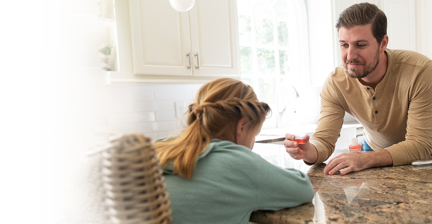 Parent giving their child medication