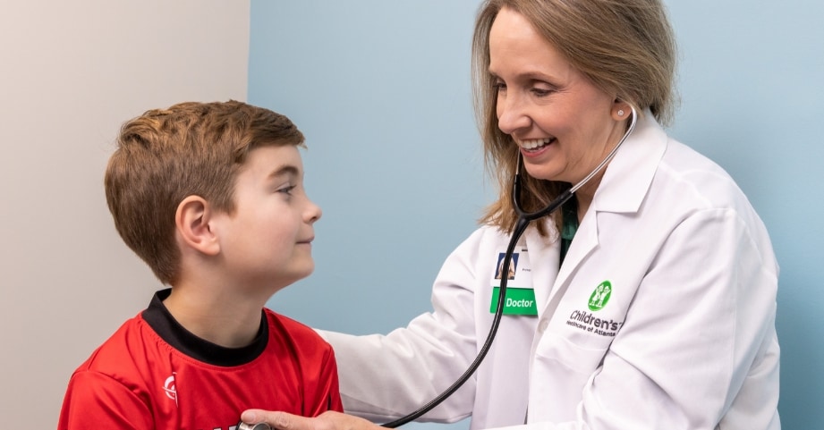 Dr. Tammy Williams checking heart of elementary school aged boy