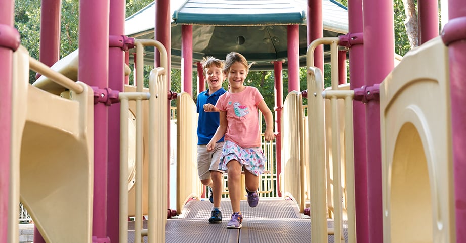 Preschool children running across jungle gym