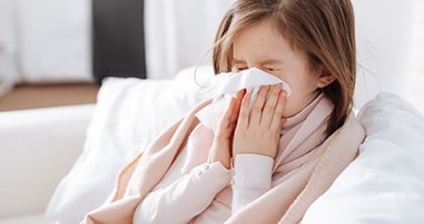 Girl with the flu blowing nose