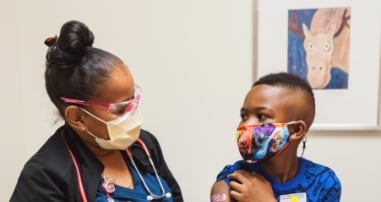 child with nurse after vaccine