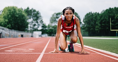 Teen female track runner prepares to race.