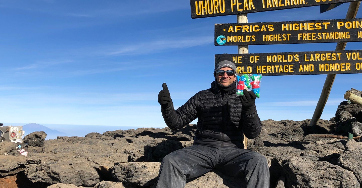 Dr Krish on top of mountain in Tanzania