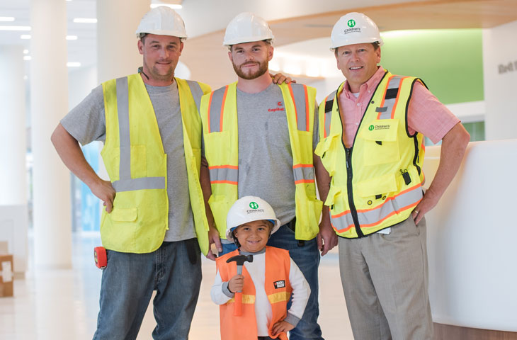 pediatric patient boy with construction workers in new building