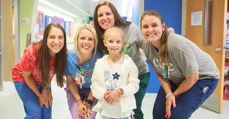 pediatric oncology nurses gathered around pediatric cancer patient