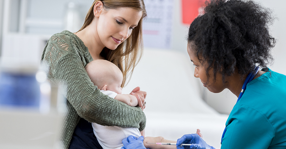 Nurse giving an infant boy the flu shot