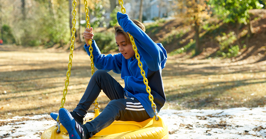 Boy playing on tire swing