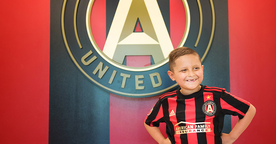 Andrew Jimenez with pediatric cancer smiling in Atlanta United jersey