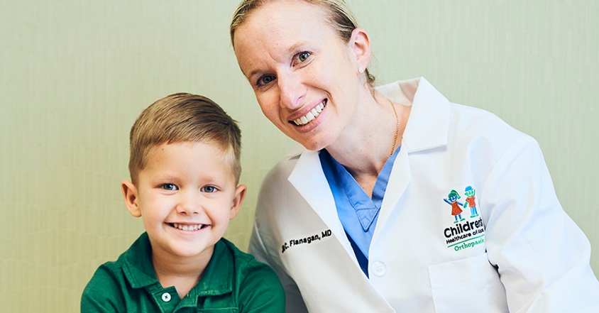 Boy with limb deficiency smiling with pediatric orthopedist