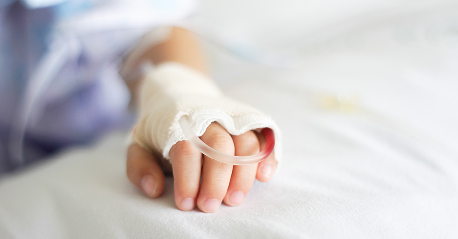 A child rests in bed after waking up from surgery 