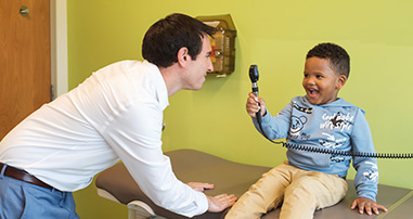Boy and doctor with ophthalmoscope