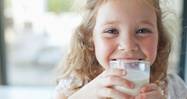 Child holding a cup of milk