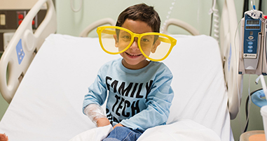 Neuro spine care patient smiling in silly glasses. 