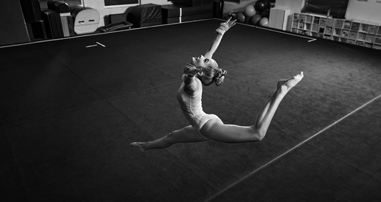 Teen gymnast leaps into the air. 