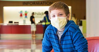 Child wearing mask in hospital lobby