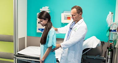 Pediatric orthopaedic specialist evaluates a scoliosis patient in the Spine Program.