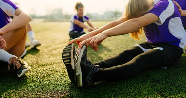 Teen athletes stretching while preparing for a new sports season  