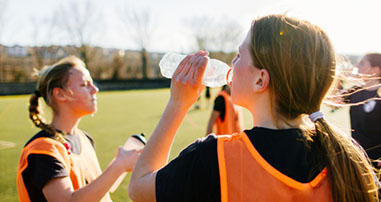 Teen athletes drinking water during sports practice