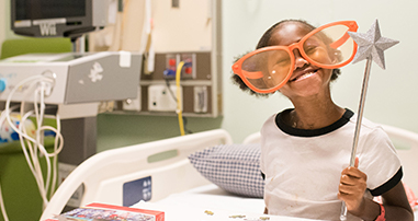 pediatric patient girl smiles with funny glasses wand and puzzle in hospital