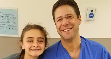 Teen scoliosis and spine surgery patient smiling with orthopedic surgeon