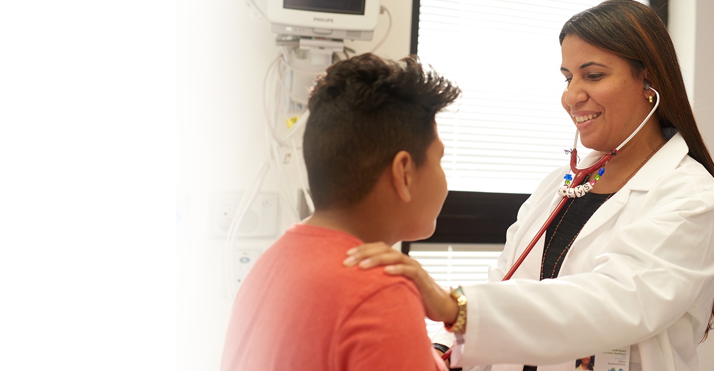 Dr. Dellys Soler-Rodriguez examining teen boy in clinic