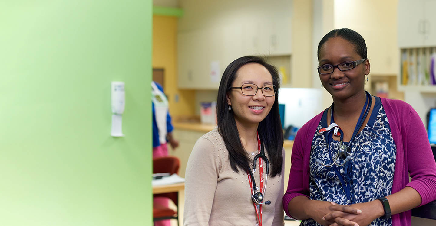 Dr. Stella Shin and Dr. Loretta Reyes standing in hall at Children’s clinic