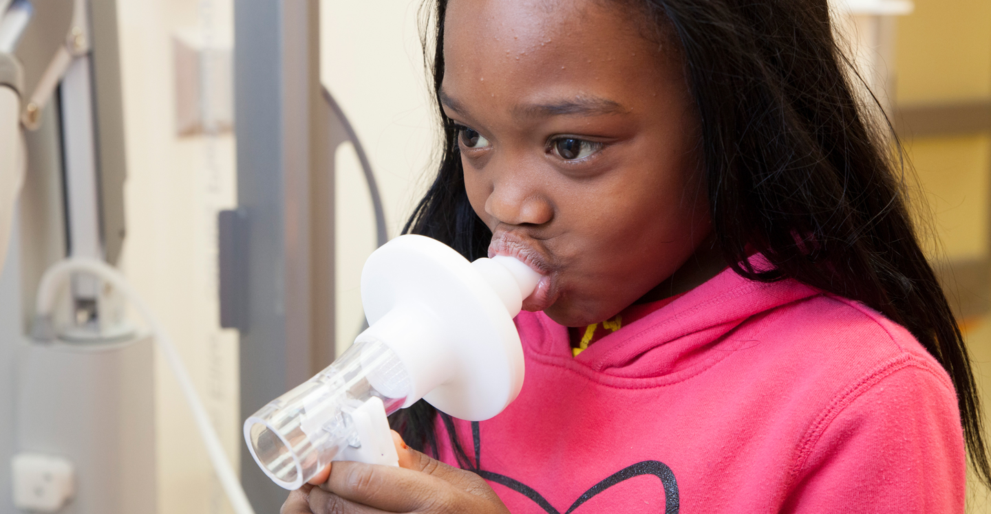 Little girl in asthma clinic does a breathing treatment.