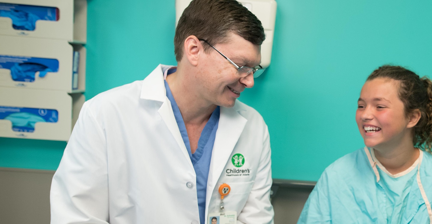 Pediatric orthopedic specialist at Children’s Healthcare of Atlanta laughs with a hip patient in clinic