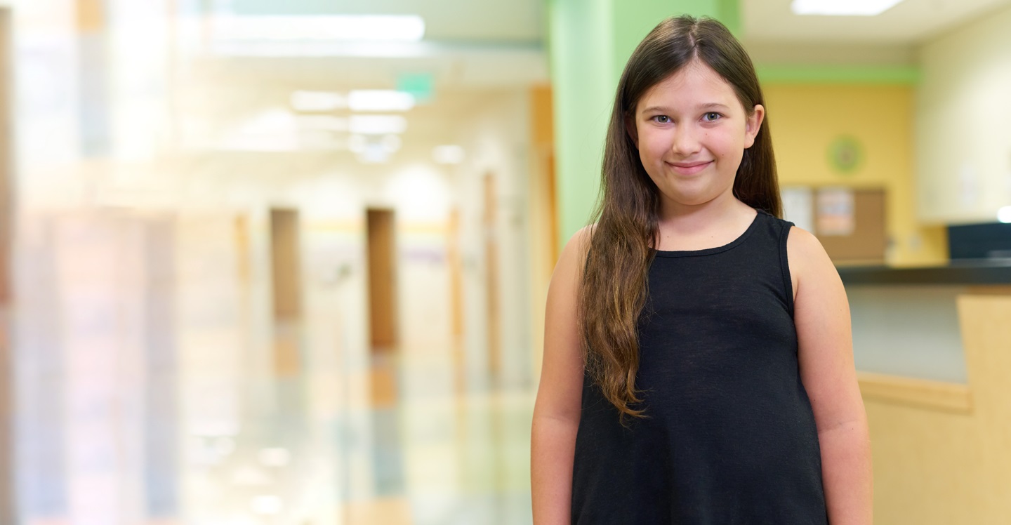 Girl smiling in hallway at Children’s Physician Group clinic