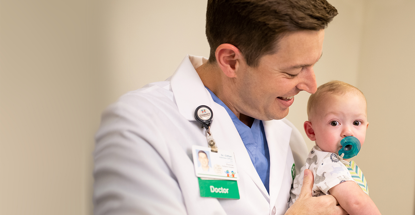 Dr. Clifton holds a baby patient before surgery.