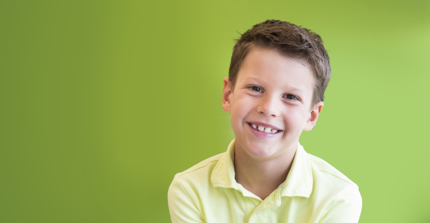 Child smiling with yellow shirt on