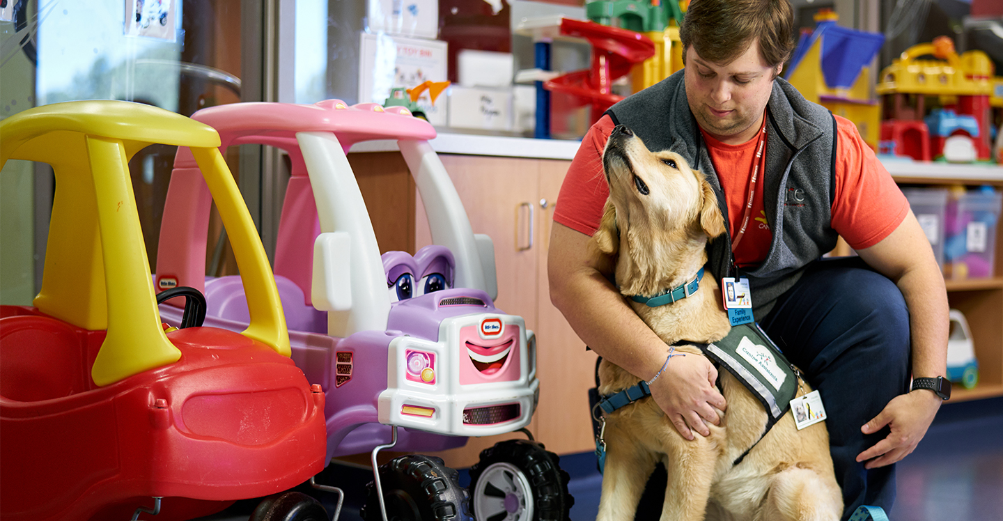 therapy dog with handler in pediatric hospital play room