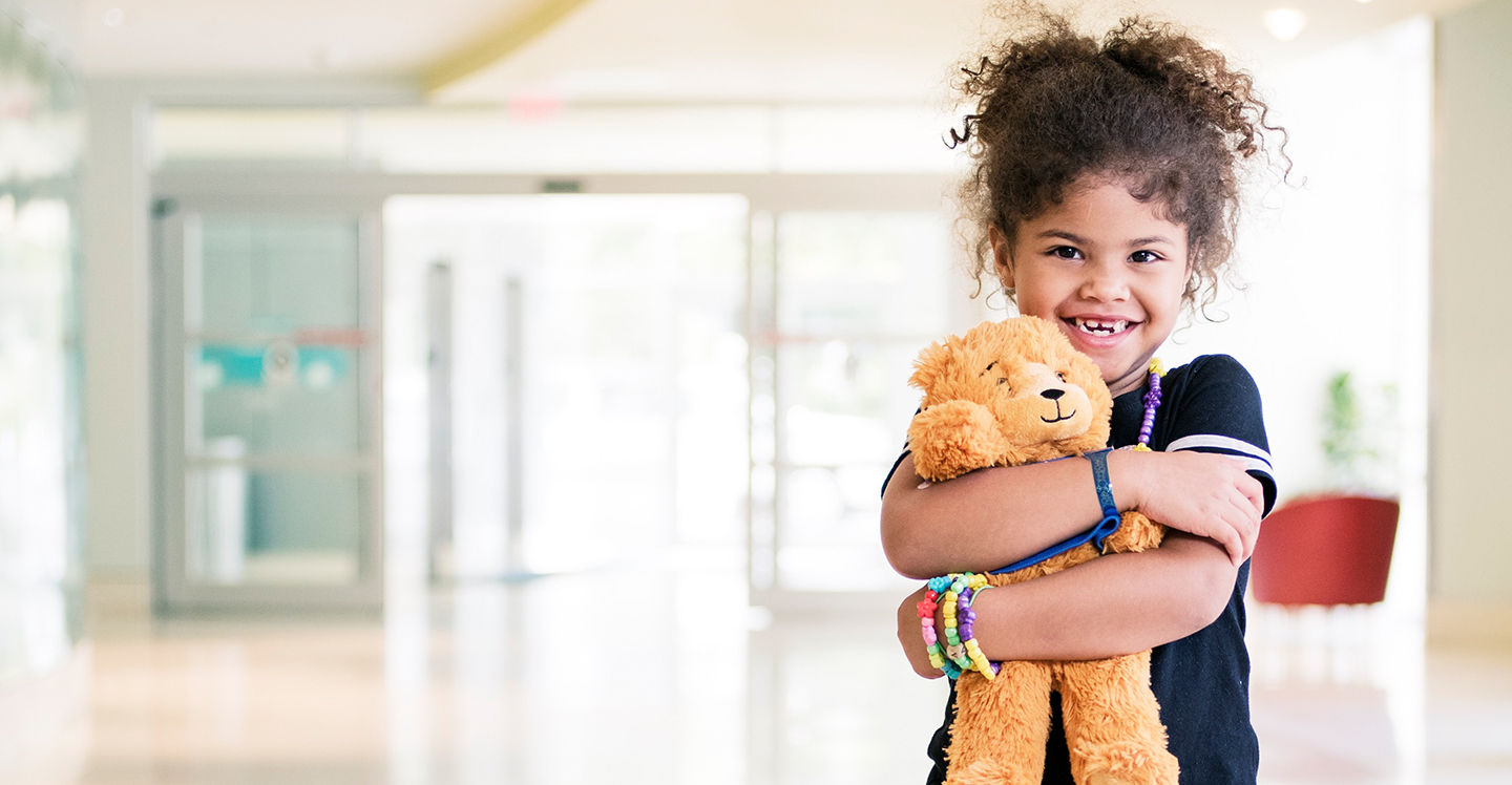 pediatric patient girl hugging teddy bear at hospital