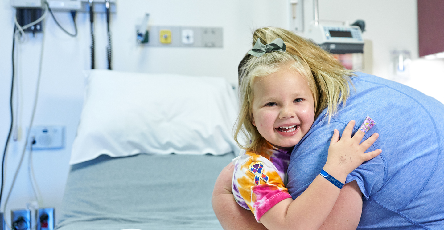 girl patient hugging visitor in pediatric hospital