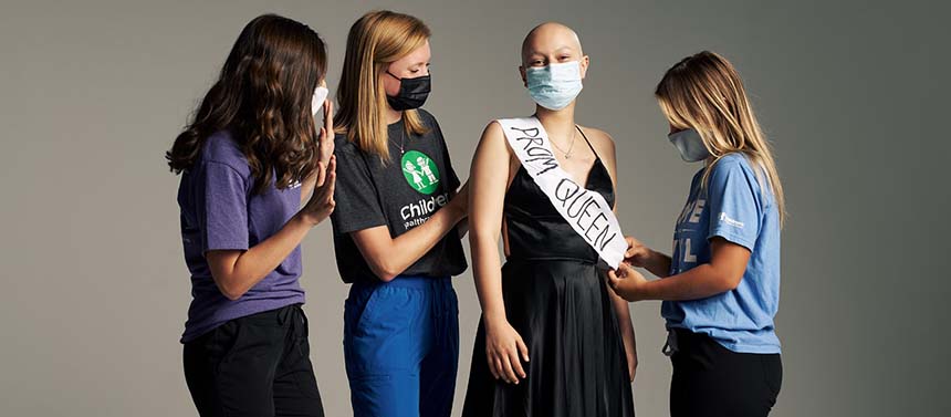 pediatric cancer patient girl smiling with nurses who threw her a prom in the hospital