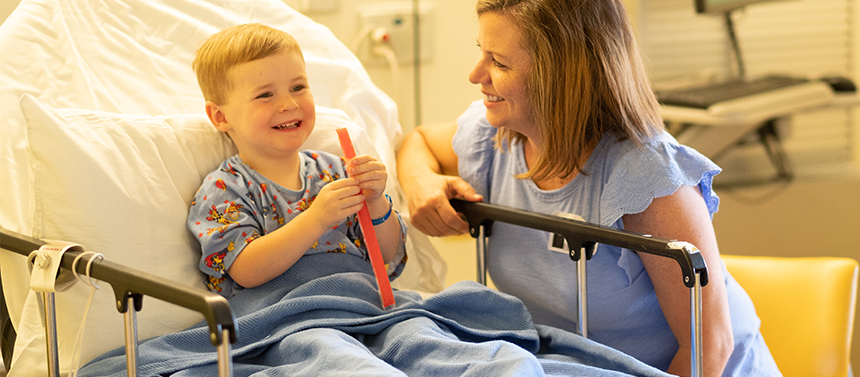 After surgery, a little boy enjoys a popsicle with his mom.