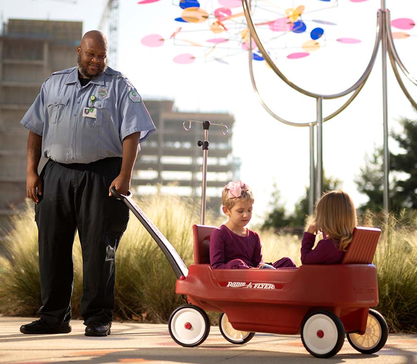 Security guard pulls patients in red wagon