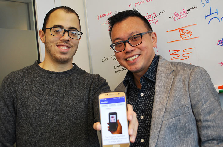 pediatric doctors proudly displaying new anemia app on smartphone
