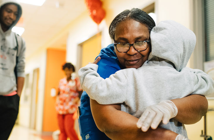 young boy hugging employee at pediatric hospital