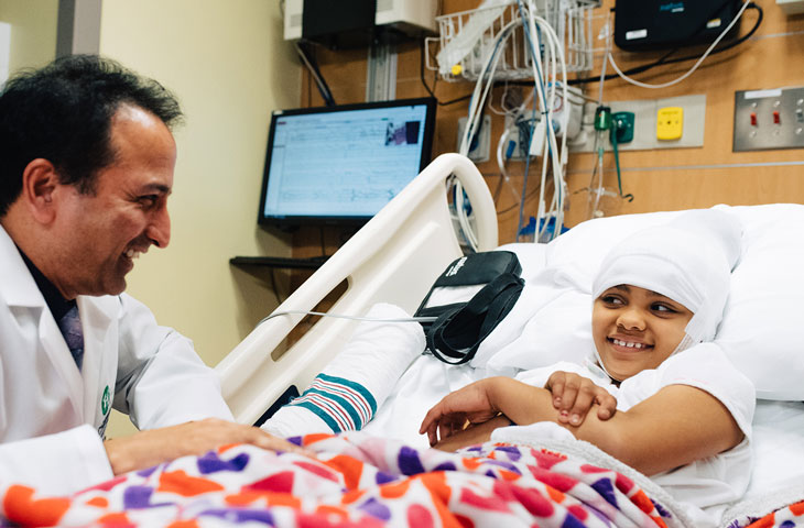 pediatric neurology doctor visiting his patient in her hospital room